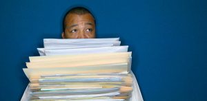 Man holding a stack of papers for employee retirement plan coverage.